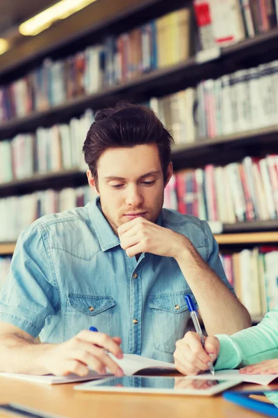 Male student with tablet pc networking in library Stock Photo