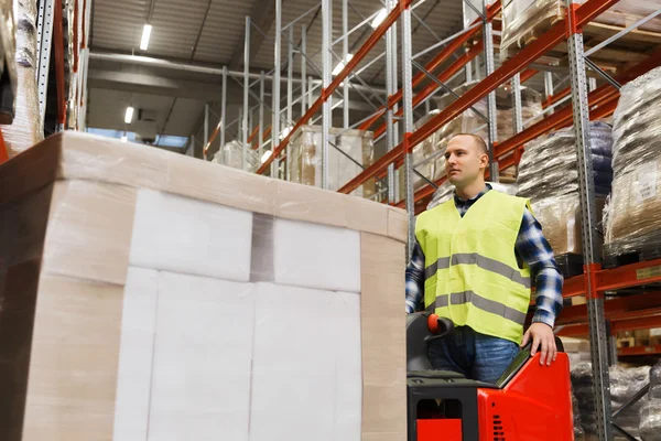 Uomo con carrello elevatore operante tablet pc a magazzino — Foto Stock