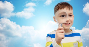 happy little boy looking through magnifying glass clipart