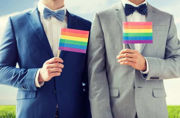 Close up de masculino gay casal segurando arco-íris bandeiras — Fotografia de Stock