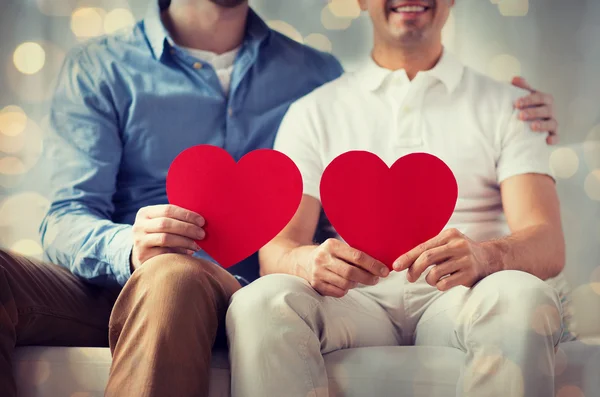 Close up de feliz gay masculino casal com vermelho corações — Fotografia de Stock