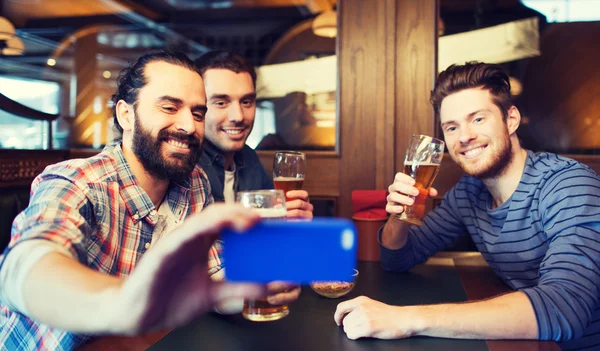 Amici maschi con smartphone bere birra al bar — Foto Stock