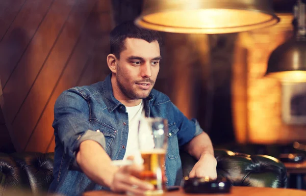 Uomo che beve birra e fuma sigarette al bar — Foto Stock