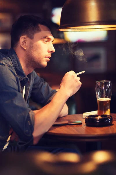 Pria minum bir dan merokok di bar — Stok Foto