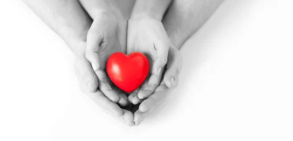 Un par de manos sosteniendo el corazón rojo — Foto de Stock