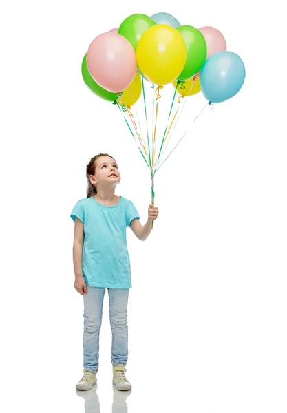 Flickan tittar upp med massa heliumballonger — Stockfoto