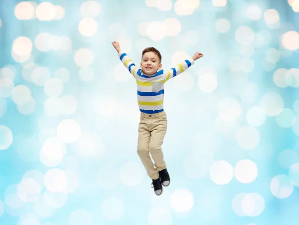 Szczęśliwy chłopiec skoki w powietrzu nad niebieskie światła — Zdjęcie stockowe