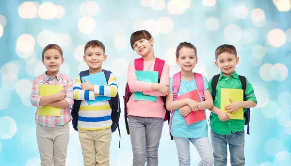 Ευτυχισμένα παιδιά με σχολικές τσάντες και σημειωματάρια — Φωτογραφία Αρχείου