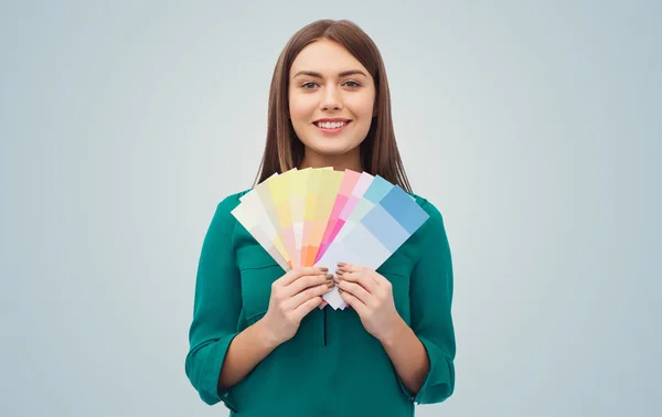 Улыбающаяся молодая женщина с цветными образцами — стоковое фото