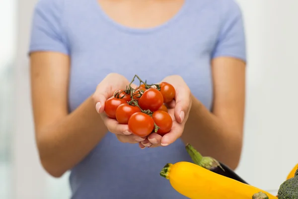 Zblízka ženy držící v rukou cherry rajčátky — Stock fotografie