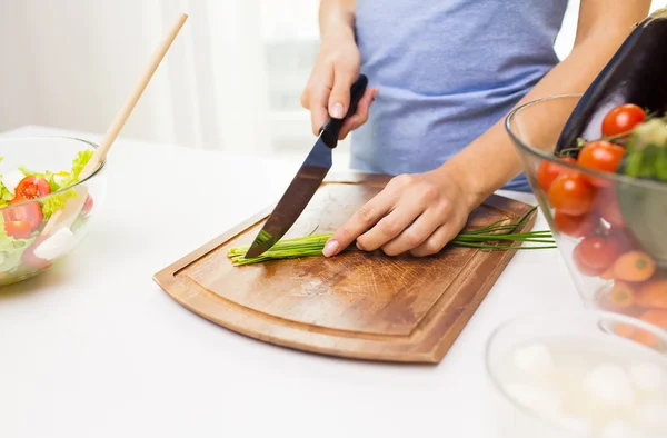 Close up of woman chopping green onion with knife — Stock Photo, Image