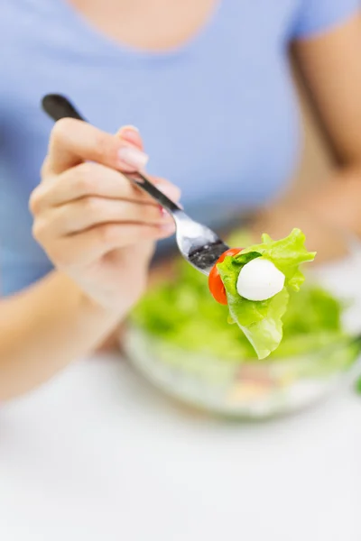 Primo piano di giovane donna mangiare insalata a casa — Foto Stock