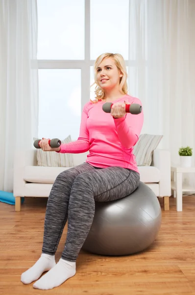 Lächelnde Frau mit Hanteln beim Training zu Hause — Stockfoto