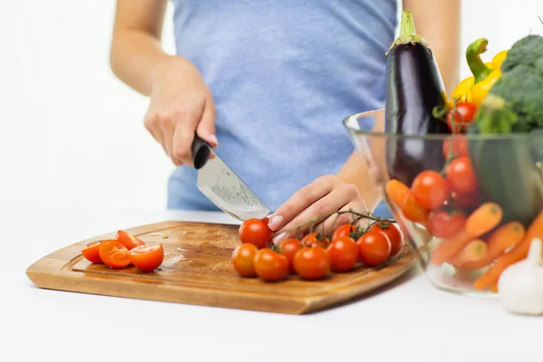 Close up of woman chopping tomatoes with knife Royalty Free Stock Images