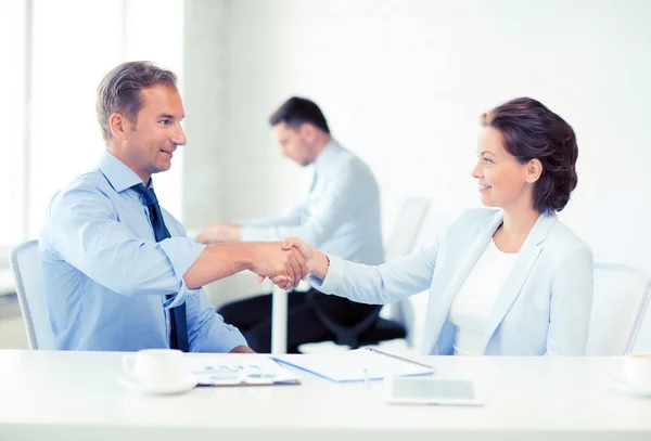 Man en vrouw schudden handen in office — Stockfoto