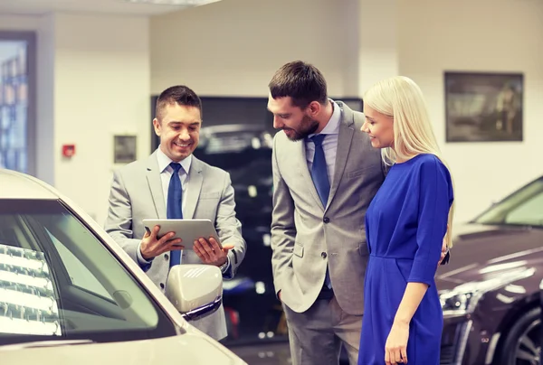 Feliz pareja con concesionario de coches en auto show o salón — Foto de Stock