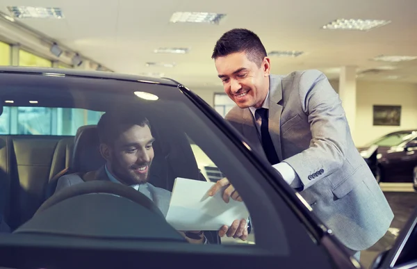 Homem feliz com negociante de carro em auto show ou salão de beleza — Fotografia de Stock