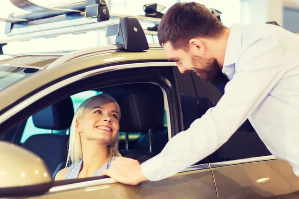 Šťastný pár koupit auto v autosalonu nebo salónek — Stock fotografie