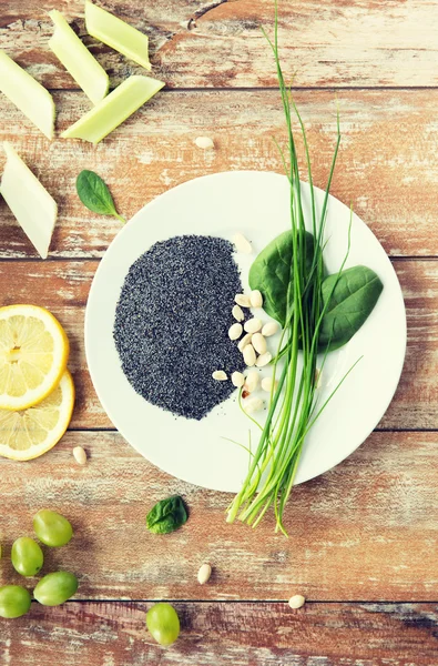 Close up of peanut, greens and poppy or chia seeds — Stock Photo, Image