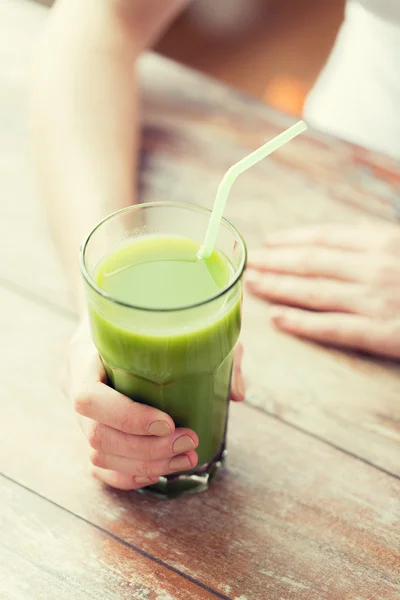 Närbild av kvinna händer med grön juice — Stockfoto