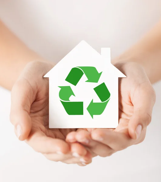 Mãos segurando casa com sinal de reciclagem verde — Fotografia de Stock