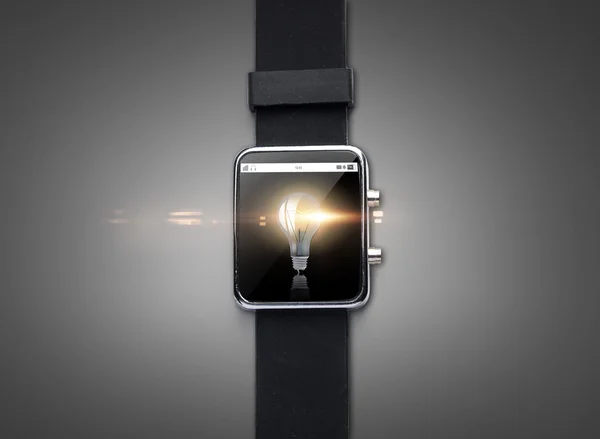 Close up of smart watch with light bulb on screen — Stock Photo, Image