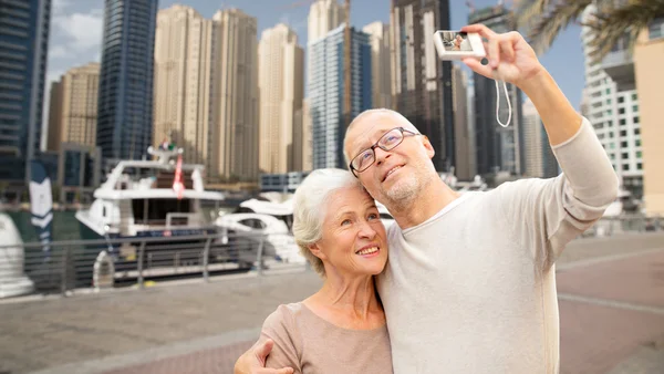 Senior couple taking selfie with camera at harbor — Stock Photo, Image