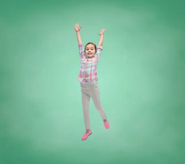 Menina feliz pulando no ar sobre placa da escola — Fotografia de Stock