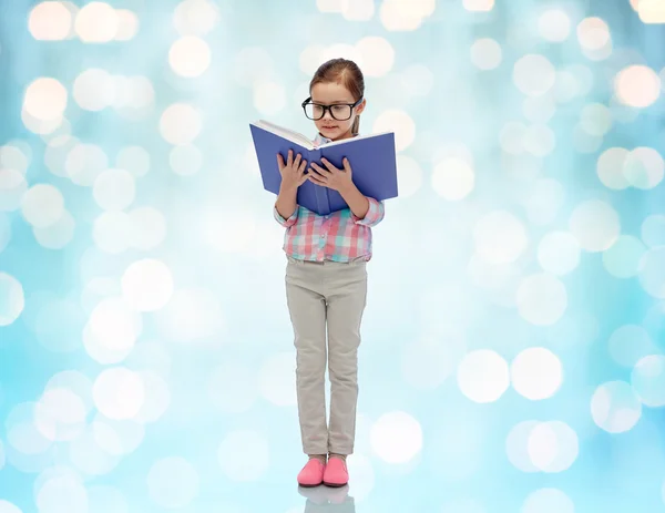 Lycklig liten flicka i glasögon läser bok — Stockfoto