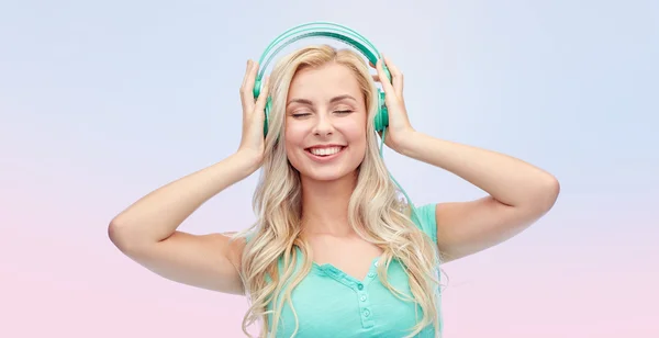 Szczęśliwa młoda kobieta lub nastolatka ze słuchawkami — Zdjęcie stockowe