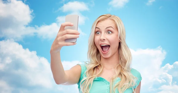 Smiling young woman taking selfie with smartphone — Stock Photo, Image