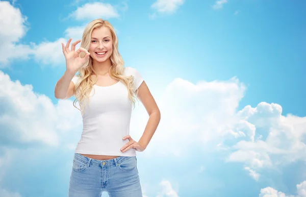 Mujer joven feliz en camiseta blanca que muestra signo ok —  Fotos de Stock