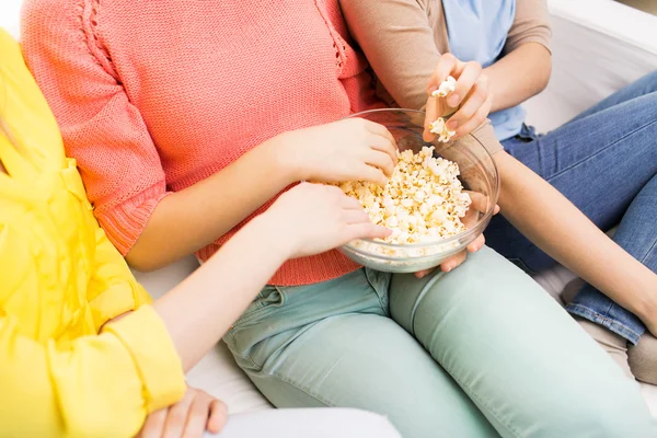 Close up of teenage girls eating popcorn at home — Stock Photo, Image