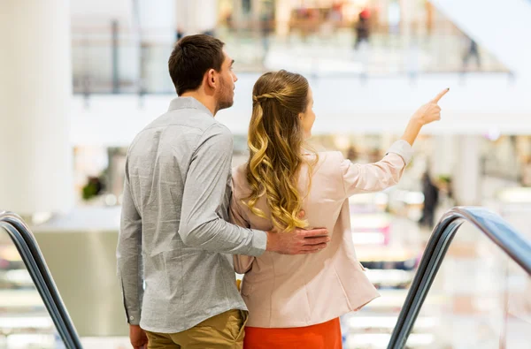 Szczęśliwa młoda para z torbami na zakupy w centrum handlowym — Zdjęcie stockowe