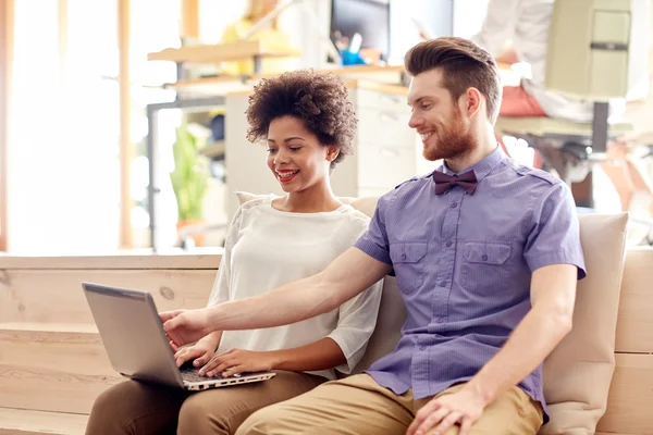 Happy creative team with laptop in office — Stock Photo, Image