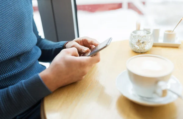 Primer plano del hombre con teléfonos inteligentes en la cafetería — Foto de Stock
