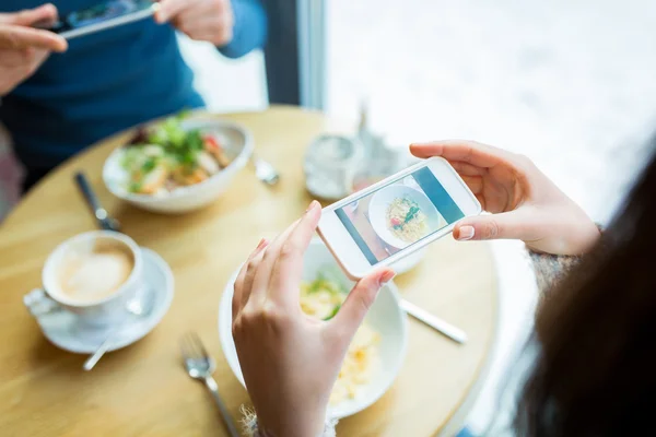 Close-up de casal imaginando comida por smartphone — Fotografia de Stock