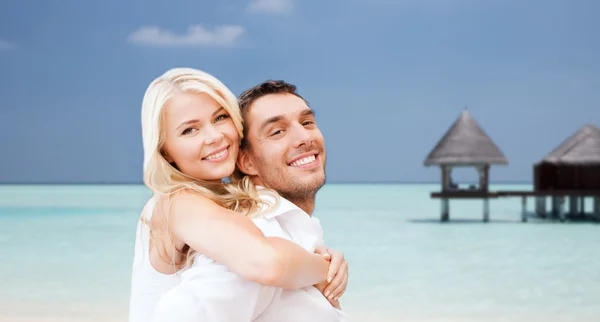 Happy couple having fun over beach with bungalow Royalty Free Stock Photos