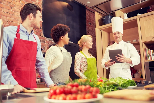 Amigos felices con la tableta PC en la cocina — Foto de Stock