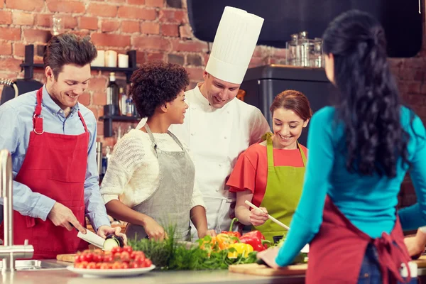 Teman yang bahagia dan koki memasak di dapur — Stok Foto