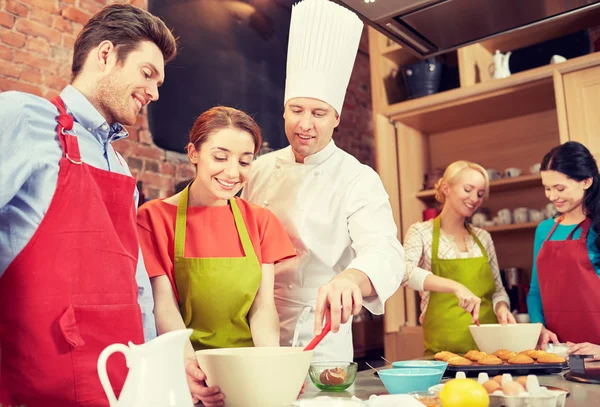 Happy friends en chef kok bakken in de keuken — Stockfoto