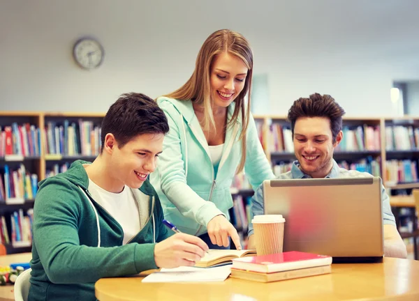 Gelukkig studenten met laptop en boeken in bibliotheek — Stockfoto