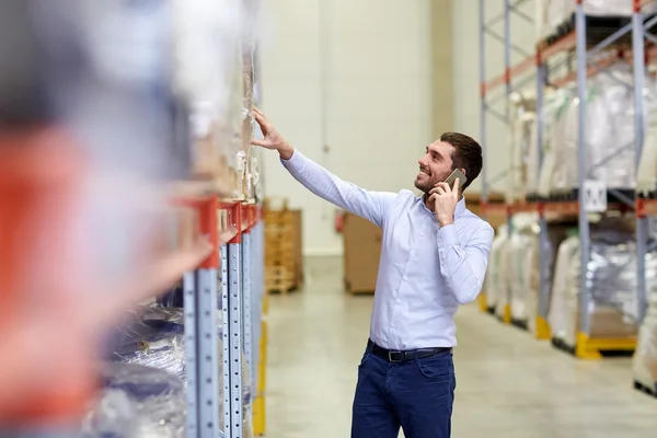 Homem feliz chamando no smartphone no armazém — Fotografia de Stock