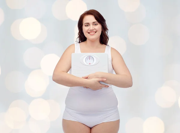 Happy young plus size woman holding scales — Stock Photo, Image