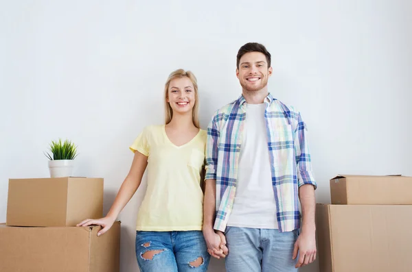 Sonriente pareja con grandes cajas moviéndose a nuevo hogar — Foto de Stock