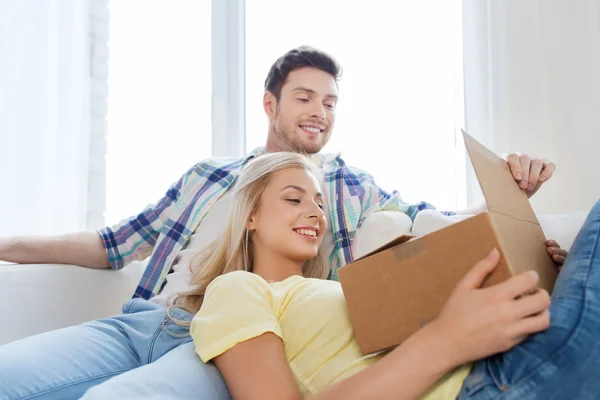 Smiling couple with cardboard box at home — Stock Photo, Image