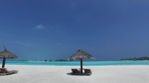 Palapa e espreguiçadeiras por mar na praia das maldivas — Vídeo de Stock