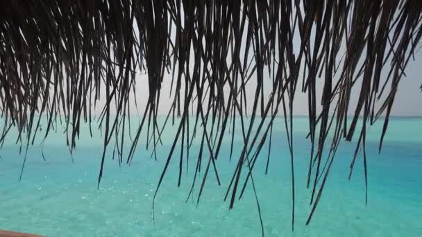 Blick auf Bungalow Stroh Schuppen und Meer — Stockvideo