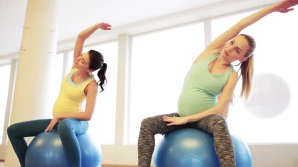 Glada gravida kvinnor utövar på fitball i gym — Stockvideo