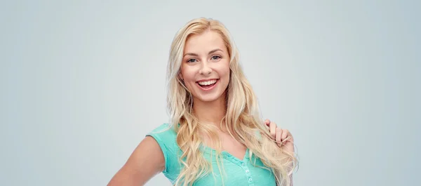 Sonriente joven mujer sosteniendo su hebra de pelo — Foto de Stock